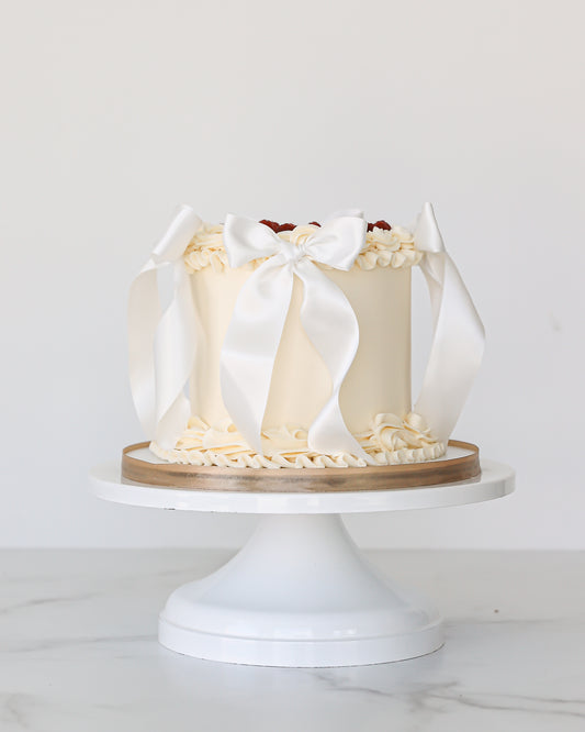 Vanilla buttercream Mother’s Day cake with white satin bows