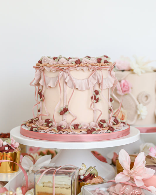 Vintage Mother’s Day cake display with pastel desserts and florals