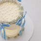Close-up of a blue velvet ribbon bow on Bluebell Bow mini cake with ribbon trailing down the side