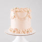 Charlotte vintage cake in soft blush with beaded pearl garland, ruffled piping, and pink rose accents