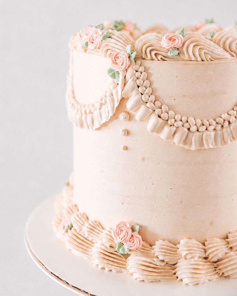 Close-up of Charlotte's beaded pearl garland with fringe tassel and piped pink roses