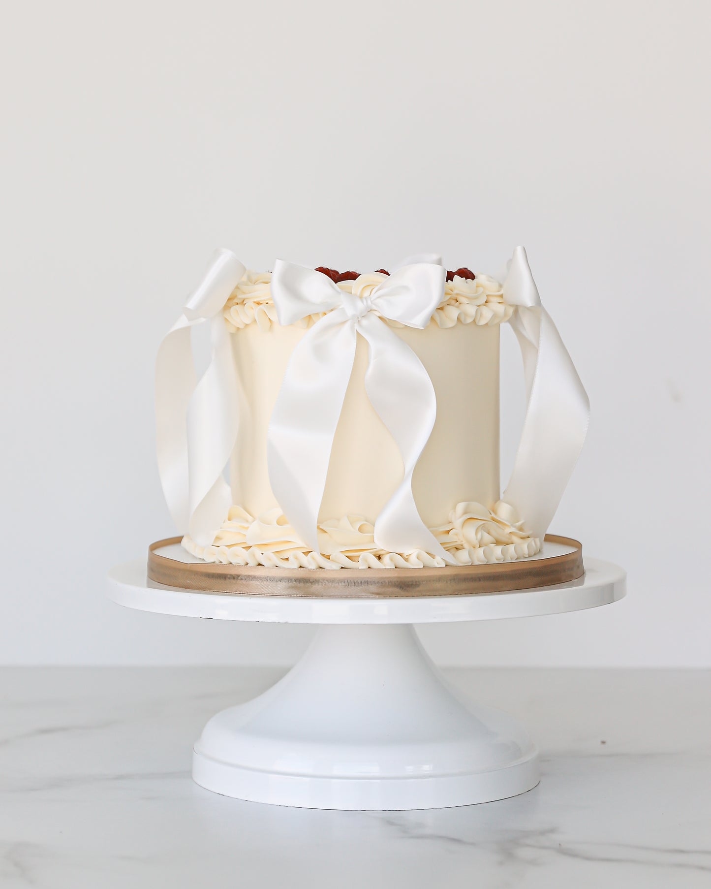 Vanilla buttercream Mother’s Day cake with white satin bows