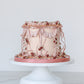 Vintage pink buttercream Mother’s Day cake with ruffles and florals