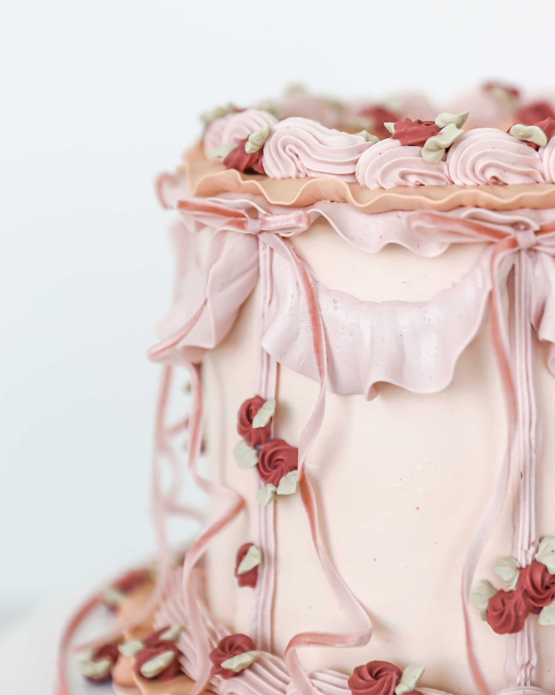 Close-up of ruffled buttercream and piped floral detailing