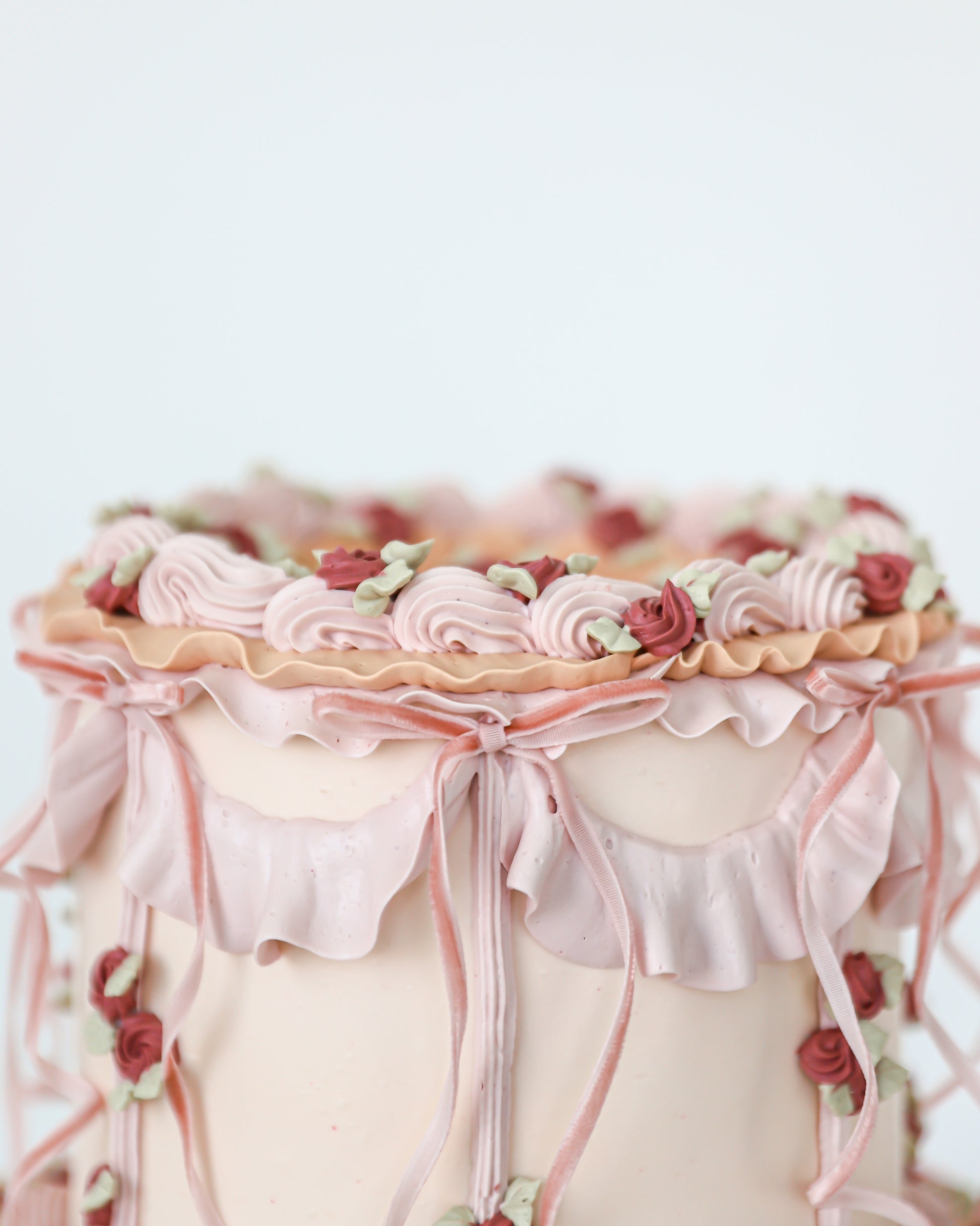 Top edge detail of vintage cake with pink swags and florals