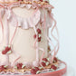 Side detail of blush buttercream cake with ribbon piping and florals