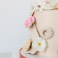 Side detail of floral buttercream cake with soft pink and ivory bloom