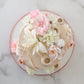 Top view of floral buttercream cake with blush and ivory silk flowers