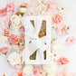 Gift box with seeded cake tied with white ribbon and pastel flowers