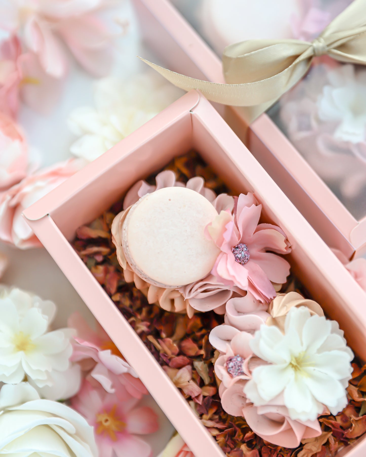 Blush pink cakelet gift box with macaron and floral buttercream design