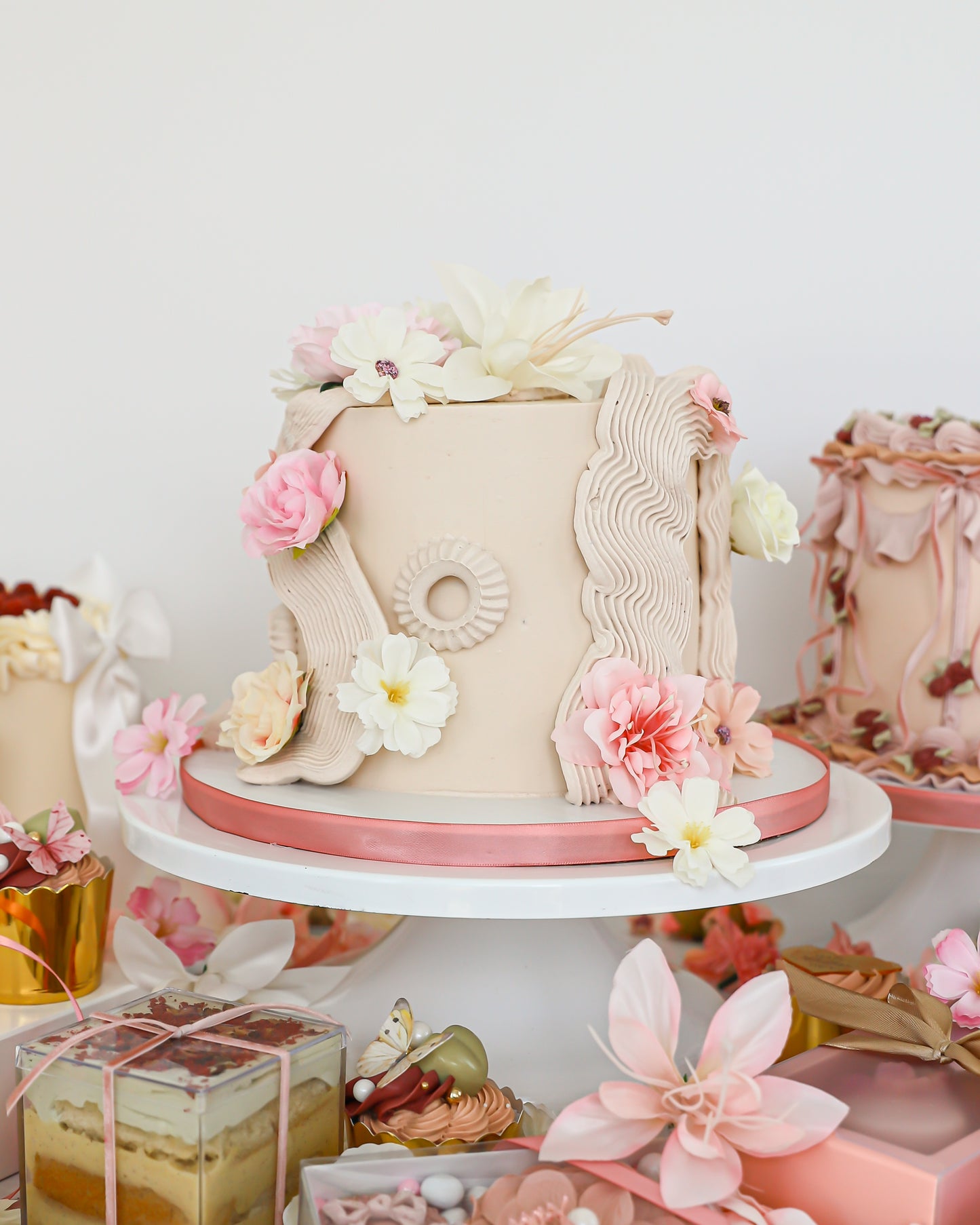 Floral Mother’s Day cake display with pastel desserts and gift boxes