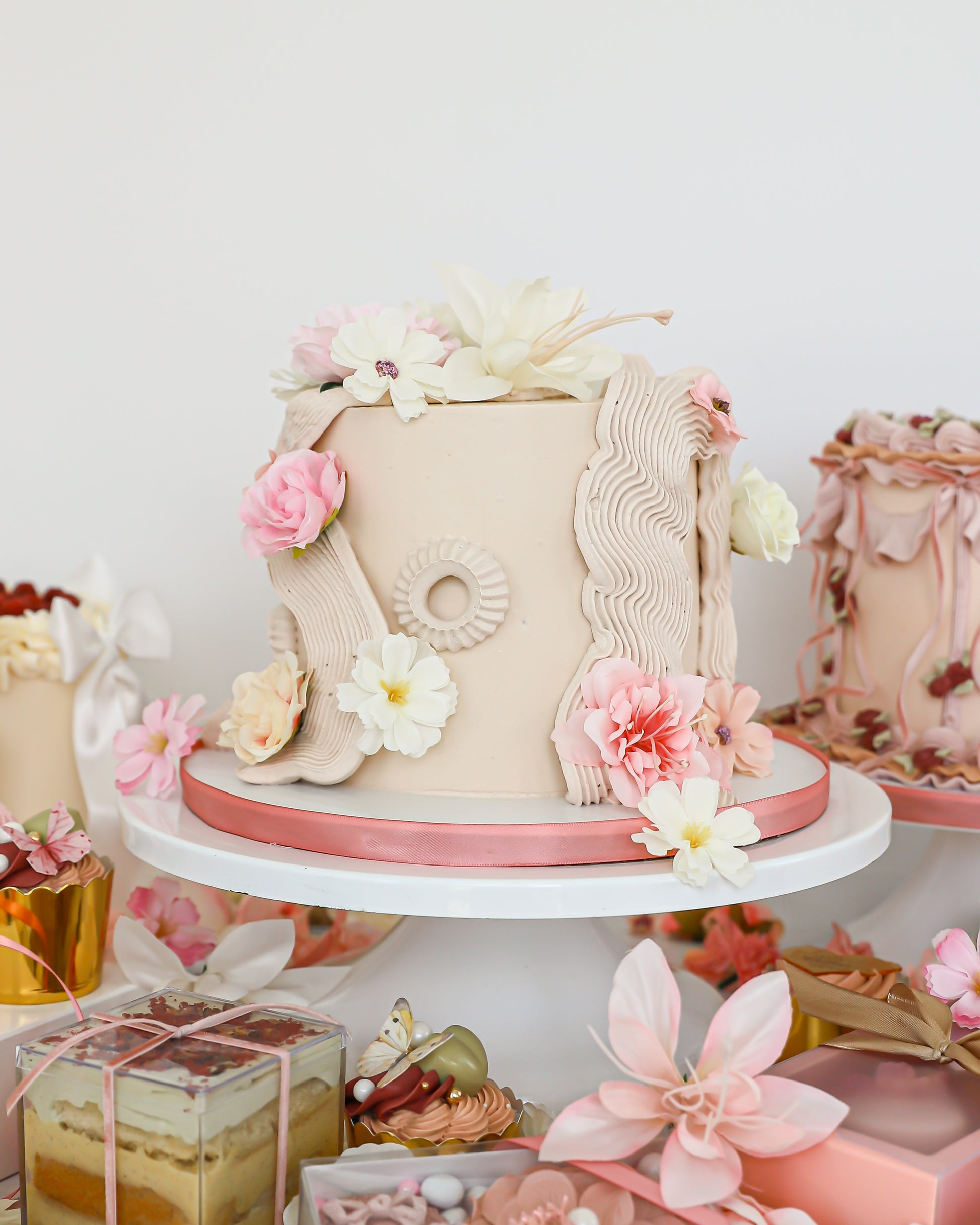 Floral Mother’s Day cake display with pastel desserts and gift boxes