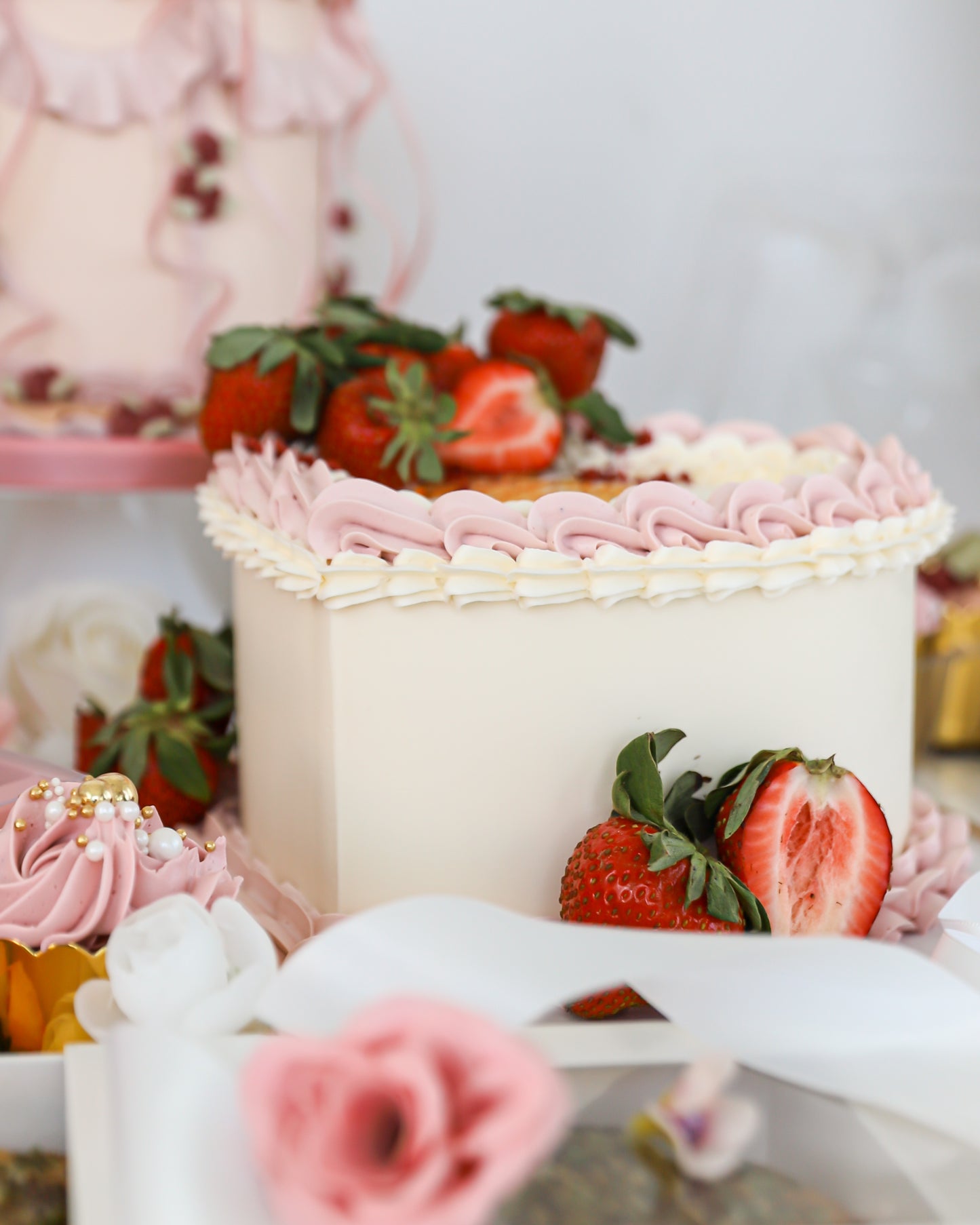 Strawberry cake display with pastel desserts and florals