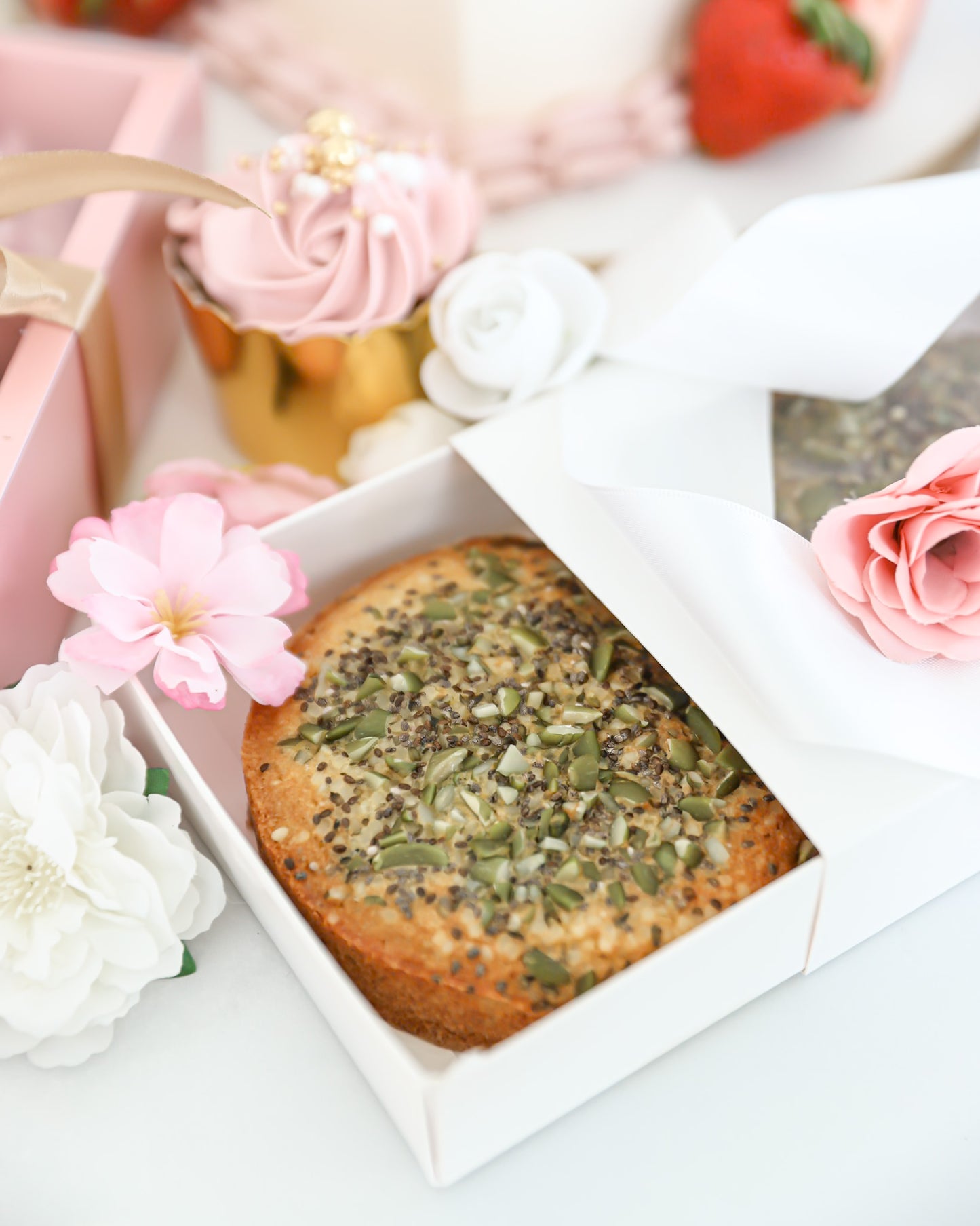 Close-up of seeded mini cake in white bakery gift box