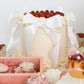 Mother’s Day cake display with bows, raspberries, and pastel desserts