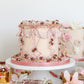 Vintage Mother’s Day cake display with pastel desserts and florals