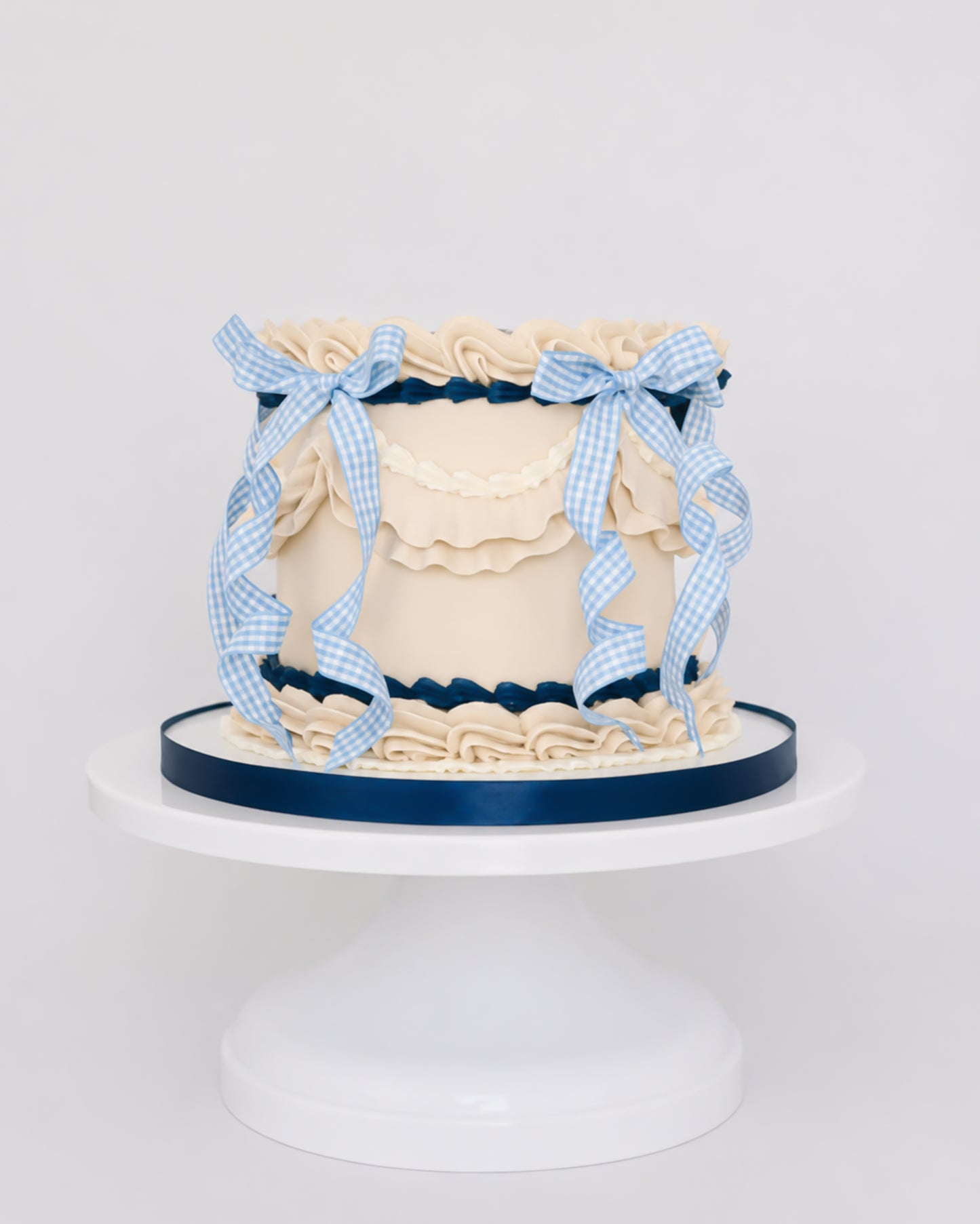 Sweetie Pie vintage lattice buttercream cake with cream ruffles, navy scalloped borders, and blue gingham ribbon on a white cake stand